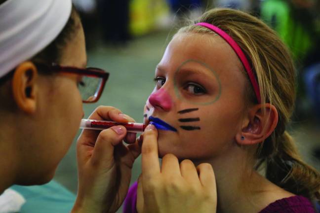 Furry, feathered and slimy friends Anneke Kuperus of Wantage picks her colors for face painting by Leibby Keegan.