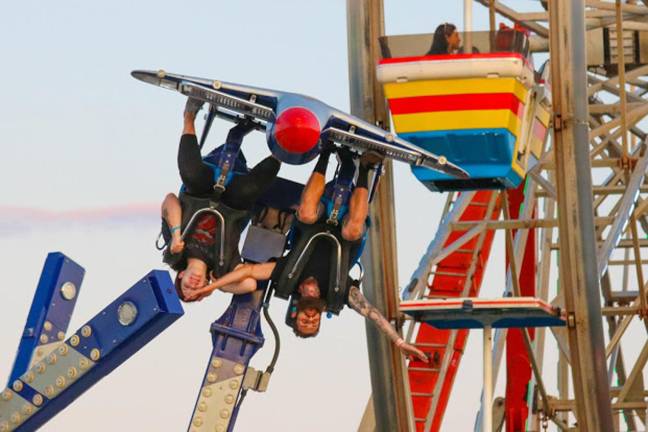 A family soars through the evening sky on a ride at the Sussex County Fair on Sunday, Aug. 11, 2019.