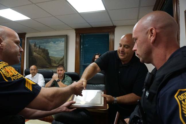 Sergeant Stephen Gordon, left, receives a plaque from Ogdensburg Mayor Steve Ciasullo with Patrolman Christopher Geene.