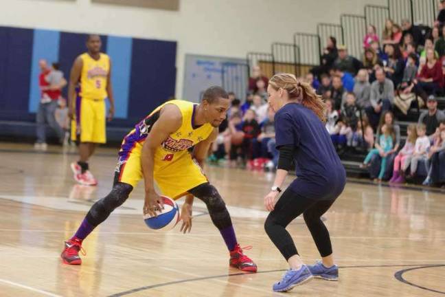 Harlem Wizards dazzle locals on the court Harlem Wizard Devon "Livewire" Curry does some fancy dribbling while shadowed by an opponent.