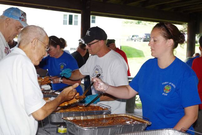 At right, Christina Marks of the Sussex County Division of Senior Services helped to serve the trays of hot food that included pulled pork and baked beans.