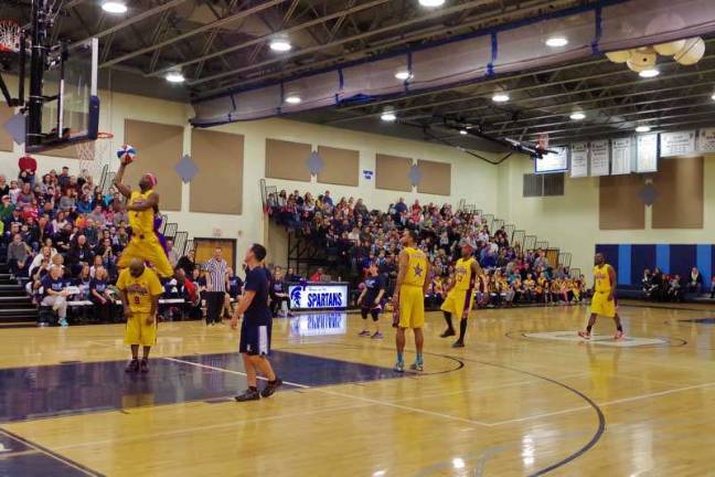 Harlem Wizard Lamarvon &quot;Showtime&quot; Jackson jumps over teammate Arnold &quot;A-Train&quot; Bernard during an amazing trick shot.