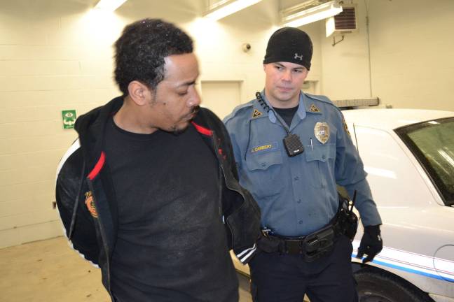 Sparta police nab alleged thieves Officer Adam Carbery escorts Leevan Lawrence into the Sparta Police DepartmentþÄôs cellblock. (Photo Courtesy of the Sparta Township Police Department).