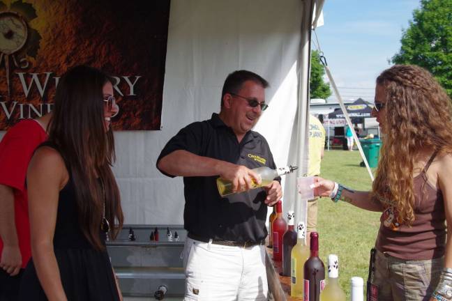 At center, Chief Operating Officer Larry Ciccarelli of Hardyston's Cava Winery and Vineyard is shown pouring some wine for a potential customer.