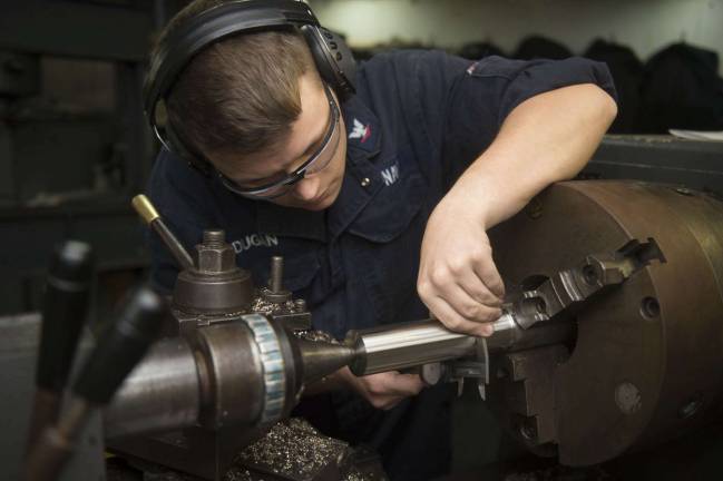 Machinery Repairman 3rd Class Thomas Dugan, from Oak Ridge, fabricates a pipe using an engine lathe aboard the amphibious dock landing ship USS Oak Hill on Oct. 16. Oak Hill, deployed as part of the Kearsarge Amphibious Ready Group, is conducting naval operations in the U.S. 6th Fleet area of operations in support of U.S. national security interests in Europe.