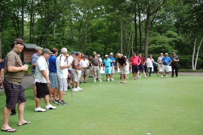 Golfers line up to compete in the Putting Contest held at the Alonso Strong Golf Outing.
