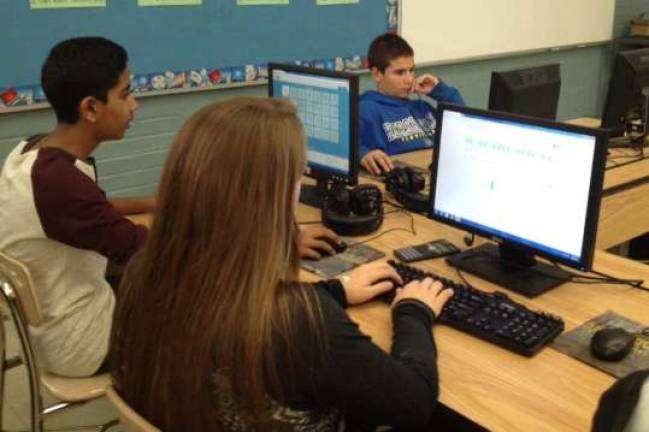Harshil Bhavsar, Molly Bader, and Hunter Horn are shown in keyboarding class.