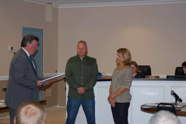 Mayor Russell Felter reads a proclamation naming Captain Eric Wilsusen as Jefferson Township Male Citizen of the Year for 2014 as his wife, Kristine, looks on.