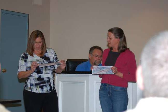 Pam Graham representing the Lake Shawnee Club and the North Jersey Regional Lake League presents checks to Debbie Alonso, mother of Sgt. Aaron Alonso. The funds were raised by a 5K Run/Walk sponsored by the Lake Shawnee Club and the team competitions sponsored by the Lake League.