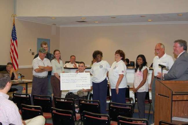 Diana Dark, president of the American Legion Post 423 Ladies Auxiliary, Andrea Drzyzga and Bibi Lakhicharran, members and Mike Drzyzga of the Legion present a check to Sgt. Aaron Alonso from the members. The funds were collected from the sale of poppies this past Memorial Day. Mayor Russell Felter is shown at the right.
