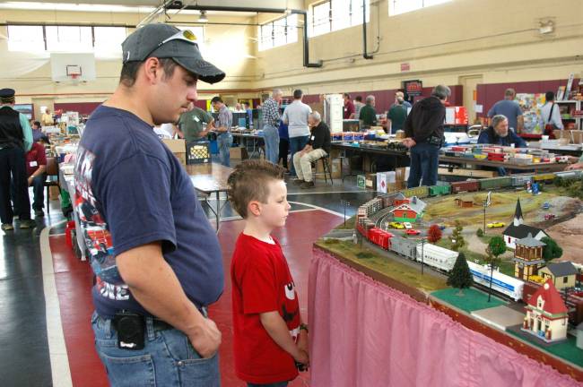 2015: The year in pictures PHOTO BY CHRIS WYMAN Franklin firefighter Michael Raperto and his son Noah DeGraw, 7, watch as a freight train goes chugging by. on May 3 Model and Toy Train Sale and Show.