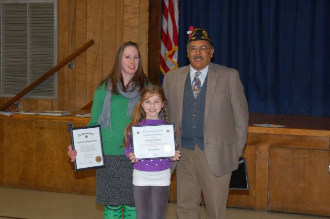 American Legion hosts coloring contest Shown in the photograph are Jennifer Tramayne-Heetema, artteacher, Brianna Mehan, first-place winner and Past Commander Legion Post 423 Clifford Williams.