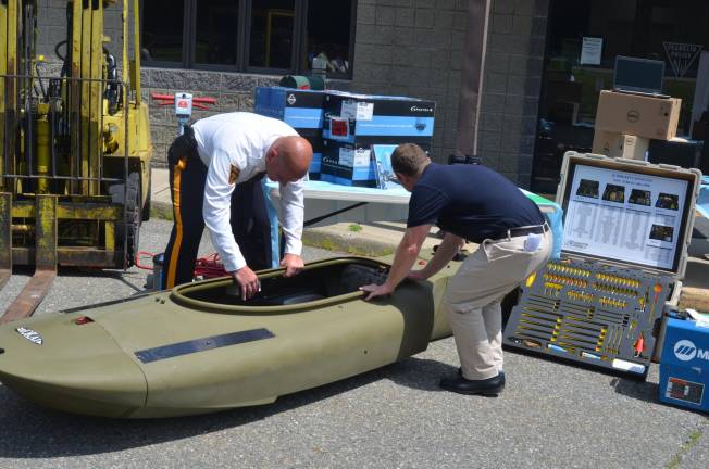 Franklin Detective-Lieutenant Nevin Mattessich and U.S. Rep. Josh Gottheimer look at a motorized kayak the department received through a Military Surplus program.