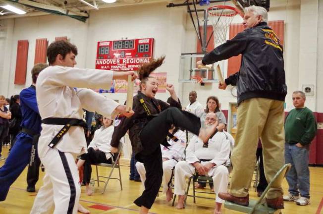 Eighteen year old Courtney Price does a flying kick and breaks a board held by her instructor Master Sam White. Price won 1st place in the weapons competition. Price represents Flying Tiger Martial Arts Academy of New Jersey.