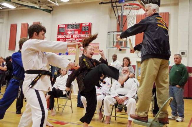Martial Arts Mania in Sussex County Eighteen year old Courtney Price does a flying kick and breaks a board held by her instructor Master Sam White. Price won 1st place in the weapons competition. Price represents Flying Tiger Martial Arts Academy of New Jersey.