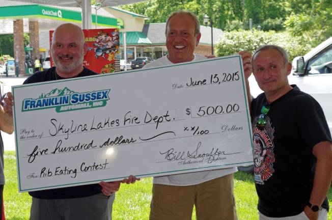 At the left, firefighter Jeff Walsh of Ringwood&#xfe;&#xc4;&#xf4;s Skyline Lakes Fire Department accepts the $500 prize to bring home to his fire department. At the center is Franklin Sussex Auto Mall owner Bill Snouffer. At the right is event emcee Howard Freeman of Promo1.
