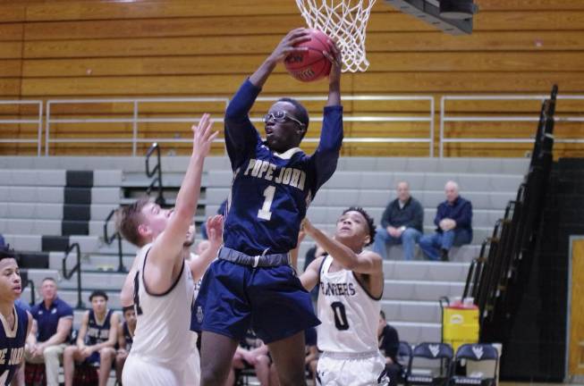 Pope John's Mike Atta grabs the ball during a rebound in the third quarter. Atta scored 21 points.