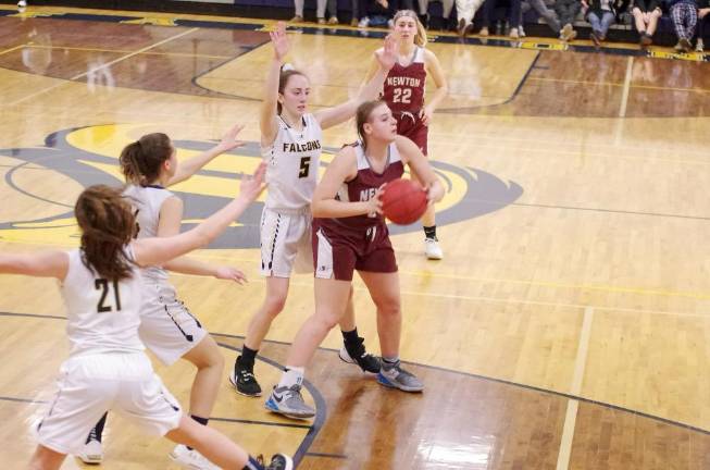 Newton's Amy Fehr holds the ball while scanning the court for an open teammate to pass to. Fehr grabbed 5 rebounds.