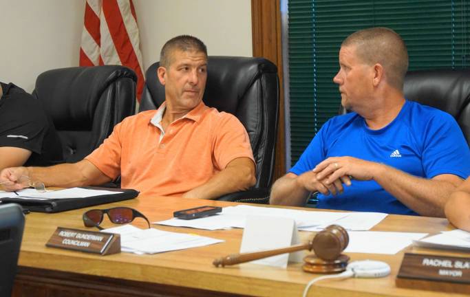 From left, Council President Peter Opilla and Councilman Robert Gunderman discuss restocking Heater's Pond.