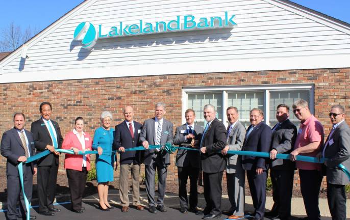 Scott Wohl, director of membership, from the Orange County Chamber of Commerce cuts the teal ribbon to commemorate the recent opening of Lakeland Bank&#xfe;&#xc4;&#xf4;s Commercial Lending Office in Highland Mills. Also joining Lakeland Bank colleagues were Brian Rivenburgh, Supervisor David Sutz, Mayor Michael Queenan.