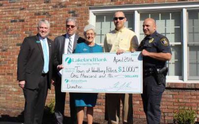 John Rath, Thomas Shara and Mary Ann Deacon of Lakeland Bank present a special donation to representatives from the Town of Woodbury Police department.