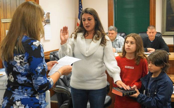 From left, Borough Clerk Robin Hough swears in Councilwoman Rachel-Lynn Slater, as her sons, Alexander and Damian, hold the Bible.