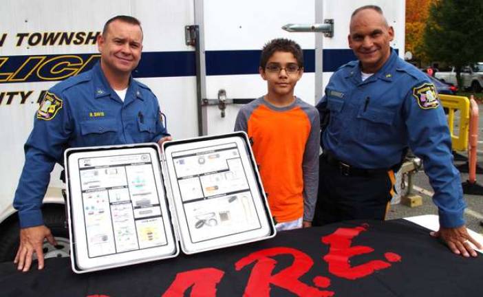 At the D.A.R.E. display in Jefferson are Police Traffic Officer Roger Davis, student Nino Denino, 11, and School Resource Officer Ivan Rodriquez. Davis is holding a Drug Identification Kit intended to help parents recognize illegal drugs and abused medications.
