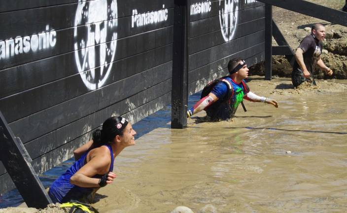 Mountain Creek hosts Spartan Race Racers make their way through the muddy water on their way to the snowy barbed wire crawl.