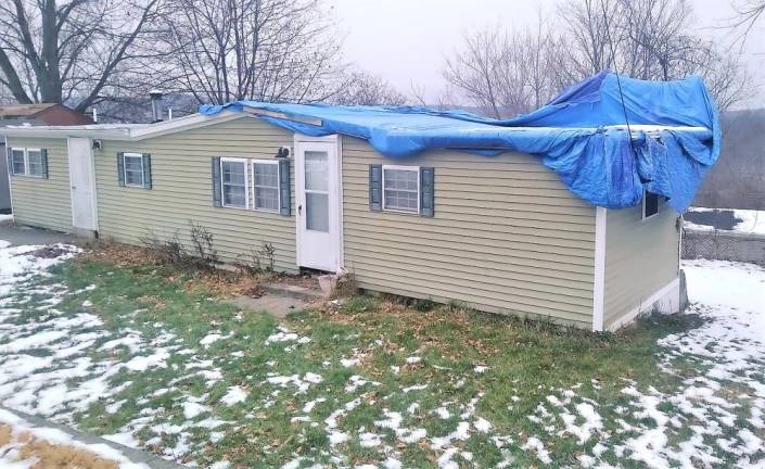 The home of John Rosa’s neighbor across the street in Franklin had roof damage from longstanding water.