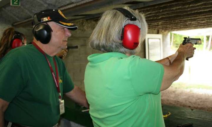 Firearm association holds women, guns class Shooting coach Mike Gubner and student Anne Simkatis are shown.