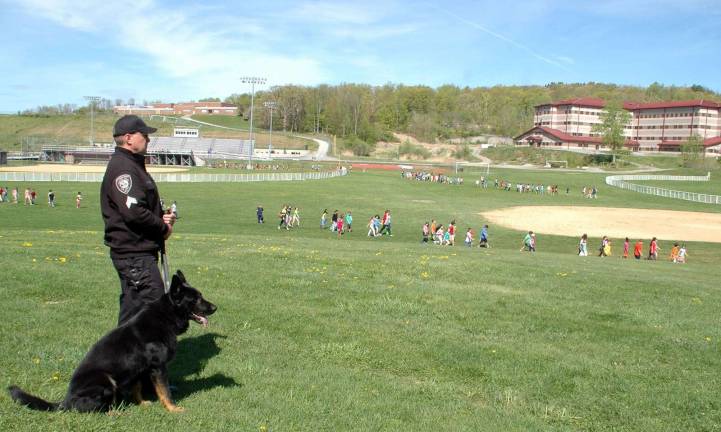 Sgt. Dave Campbell of the Orange County Sheriff's Department and Scout, an explosive detector K-9, watch as students evacuate Central Valley Elementary as part of a planned drill in May 2013.