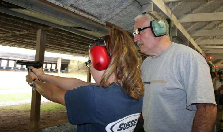 Firearm association holds women, guns class Shooting coach Frank Elmo watches student Brandi Franek.
