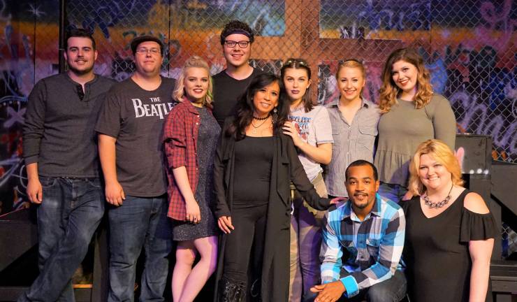 The &quot;Godspell&quot; Cornerstone Playhouse cast poses on stage with DirectorJanine Byrnes, first row on right.