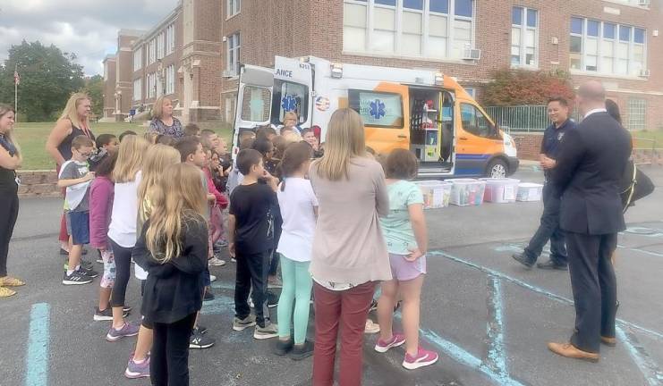 A representative from Atlantic Health System talks to Franklin Borough School students at a Stuff the Bus event.