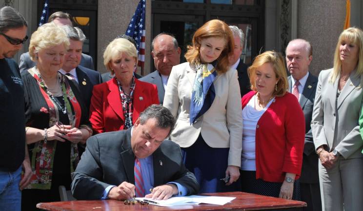 Gov. Chris Christie signs the Jessica Lunsford Act into law. Behind him, from left, are: Mark Lunsford, father of Jessica Lunsford, Senator Diane Allen (R-7), Senator Steve Oroho (R-24), Assemblywoman Mary Pat Angelini (R-11), Senator Chris Connors (R-9), Assemblywoman Nancy Munoz (R-21), Assemblywoman Alison Littell McHose (R-24), Assemblyman Pat Diegnan (D-18), and Assemblywoman Betty Lou DeCroce (R-26).