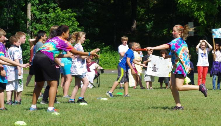 At the center, Hannah Douglas, 12, readies to pass the baton to another Spartan team member.