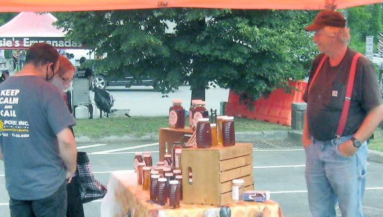 John Coco of Top of the Mountain Honey Bee Farm helps customers choose their favorite Jersey Fresh honey.(Photo by Janet Redyke)