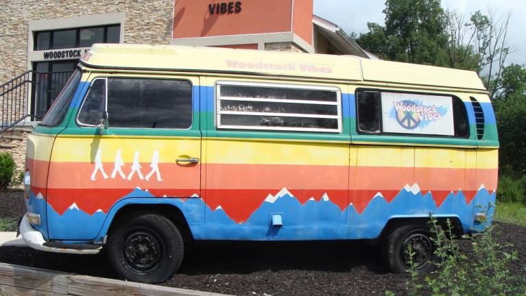 A vintage VW van is displayed out front the Woodstock Vibes Store on Route 94