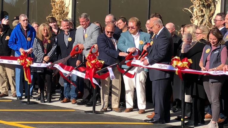 Holding huge scissors, from left, are Wantage Mayor Jon Morris; Sussex Mayor Edward Meyer; David Romano, RoNetco Supermarkets co-president and chief financial officer; Alexander Romano, ShopRite Wines &amp; Spirits manager; and Dominick Romano, RoNetco co-president and chief operating officer. (Photo by Kathy Shwiff)