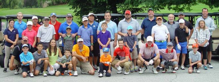 Moms, Dads, Sons &amp; Daughters pose for a photo before the start of the Mid-Summer Parent/Youth Classic at Minerals Golf Club.