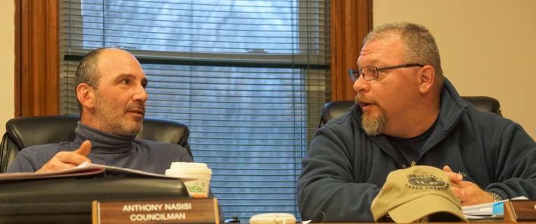 From left, Councilmen Anthony Nasisi and George Hutnick discuss money for the fireman's parade.