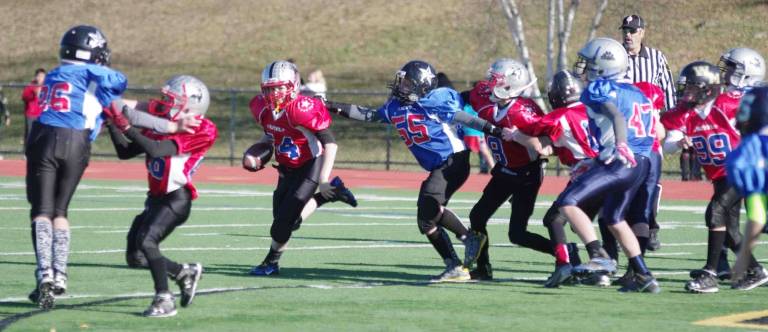 A Blue defensive lineman reaches for a Red ball carrier in the Super PeeWees game. The North Jersey Youth Football League All-Star games took place Saturday, December 5, 2015. Some of the best athletes from Passaic County and Sussex County, New Jersey in the 6th, 7th and 8th grade levels participated in three games. Macopin Middle School of West Milford, New Jersey hosted the event. The players were devided into two teams called the Red All-Stars and the Blue All-Stars. In the first game the Super PeeWees (6th grade) red all-stars defeated the blue all-stars by the score of 13-7. In the second game featuring The PeeWees (7th grade) the red all-stars and the blue all-stars ended the contest in a 6-6 tie. In the third game the Midgets (8th grade) the red all-stars defeated the blue all-stars 18-14.