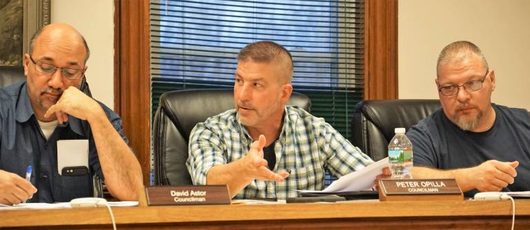 In center, Councilman Peter Opilla discusses the Beardslee Hill Dr. repairs. On left and right, Councilmen David Astor and George Hutnick listen.