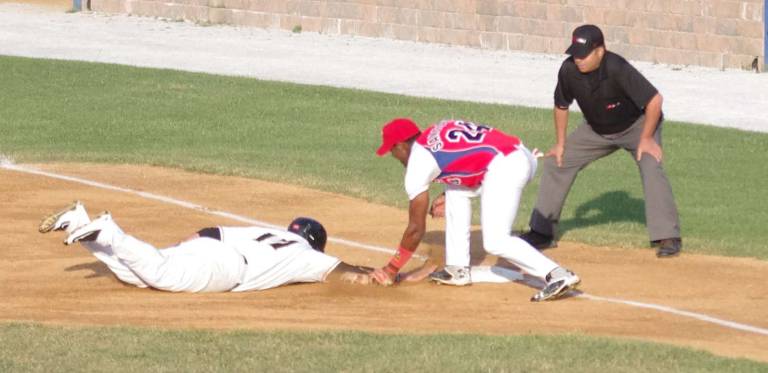 Sussex runner Dominique Taylor makes it back to first base before the tag by Cuba's Yasiel Santoya.