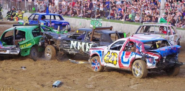 Cars bounce around at demolition derby Cars crash and smash in the arena.