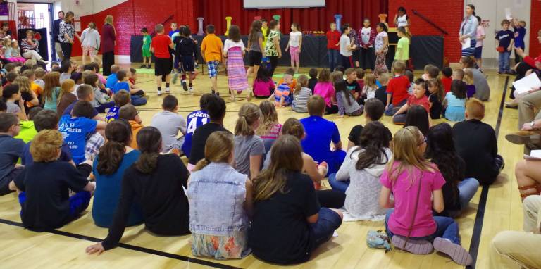 The Six Pillars of Character: trustworthiness, respect, responsibility, fairness, caring, and citizenship can be seen on the stage behind the students.