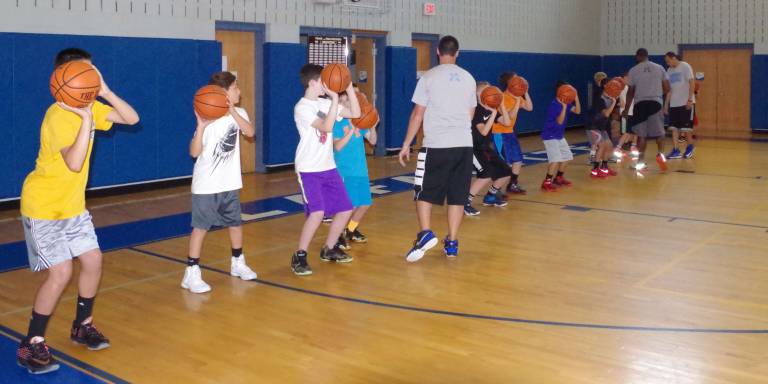 Crossroads Basketball Camp participants coached during a drill.