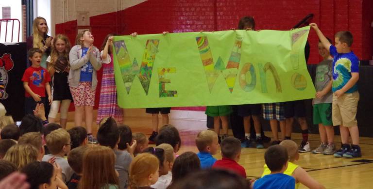 Hamburg School Holds PRIDE Assembly The students surpassed their goal of 1,000 reading points and reached 1,449. One sign included the number of points and the other declared "We Won."