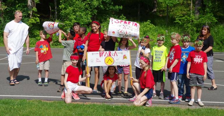 At left and wearing a toga, Hamburg School history teacher Michael Blochinger stands with the members of the Sparta team during the Greek Olympics.