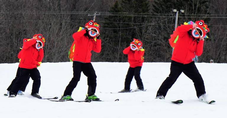 The Chinese dancing lions ski down Sugar slope.